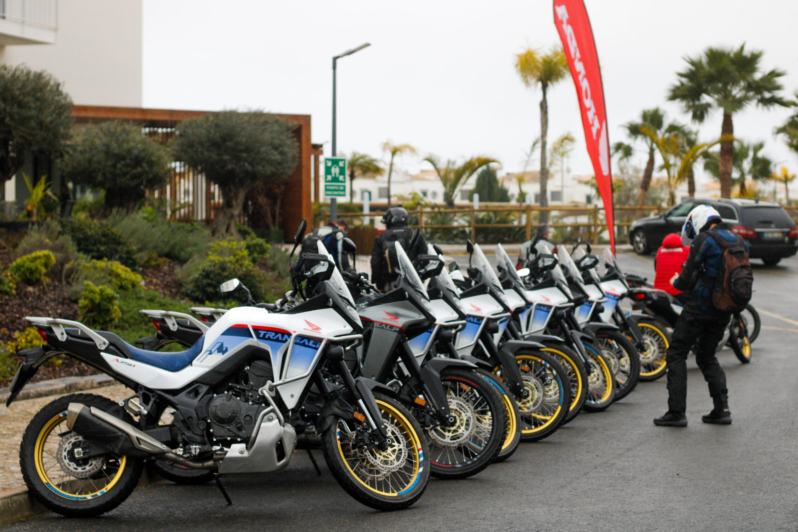 Várias motas Honda XL750 Transalp estacionadas em fila, em frente ao hotel AP Cabanas Beach & Nature, em Tavira