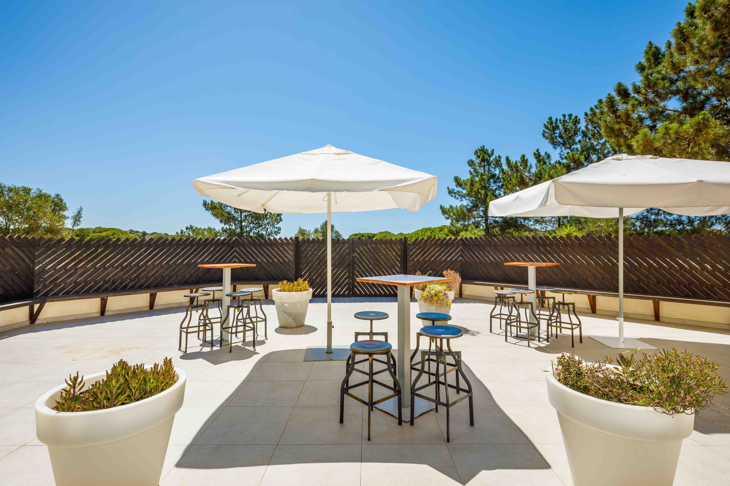 Terraço no Algarve com várias mesas, cadeiras e sombrinhas