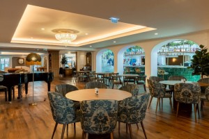 Mesas, cadeiras e piano do bar do hotel AP Dona Aninhas, em Viana do Castelo