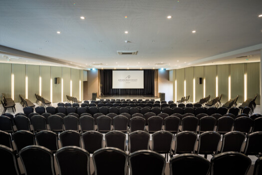 Anfiteatro no Algarve com cadeiras pretas, iluminação led e um palco com tela